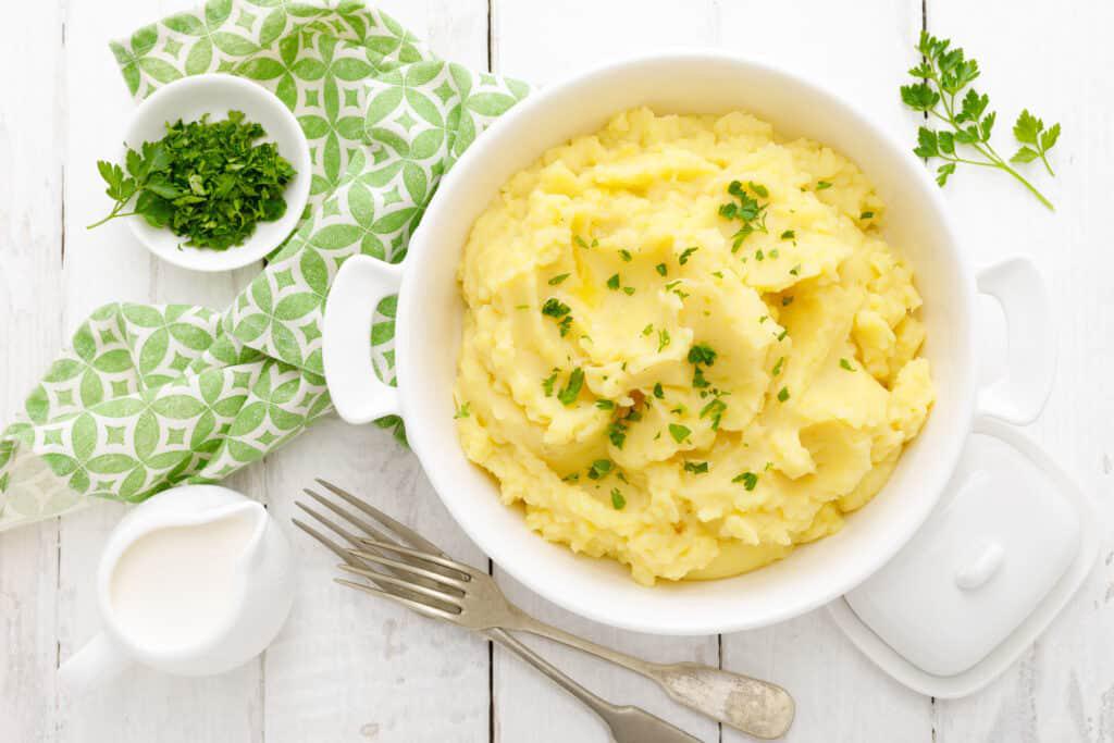 Mashed potato with butter and milk on table