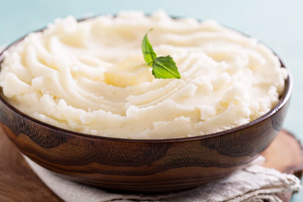 Mashed potatoes in a big wooden bowl.