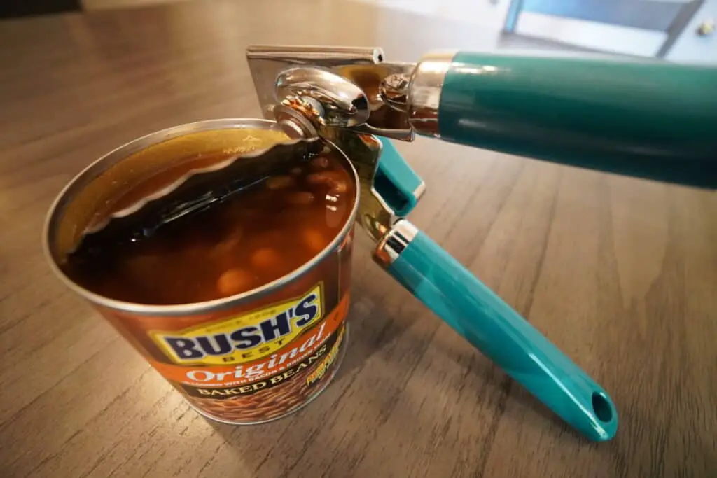 Can of baked beans being opened by a can opener.