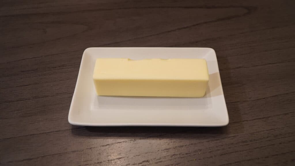 A stick of butter on a tray sitting on the counter.