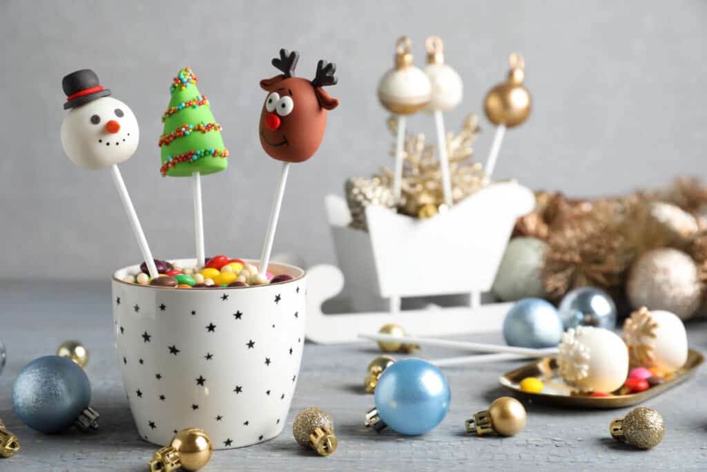 Homemade delicious cake decorated with candy canes and popcorn on gray wooden table background