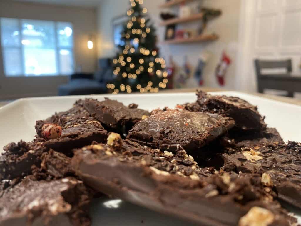 Closeup of homemade chocolate bark with Christmas tree in the background