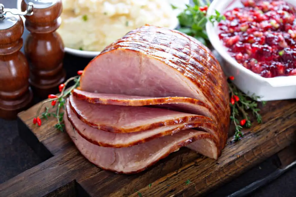 Holiday glazed ham for Christmas dinner with cranberry sauce.