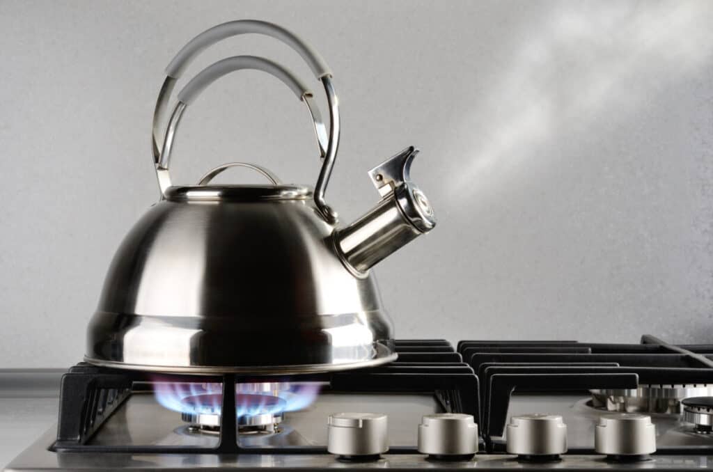 Tea kettle with apple cider on gas stove