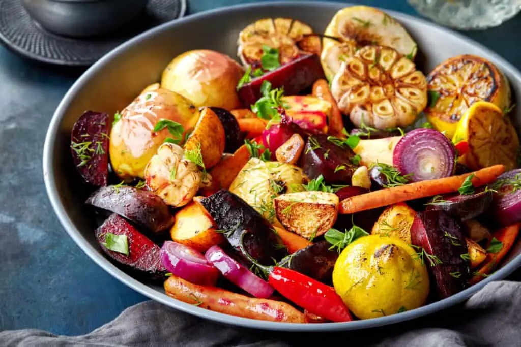 Various roasted vegetables and fruits in a gray bowl