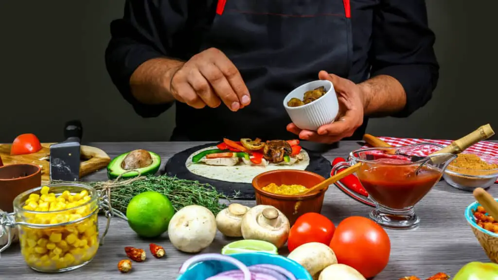 Chef preparing delicious Mexican taco at kitchen