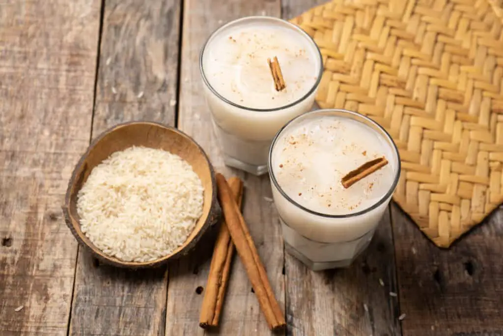 Traditional Mexican cuisine horchata, rice and cinnamon, beans and grains on wooden background
