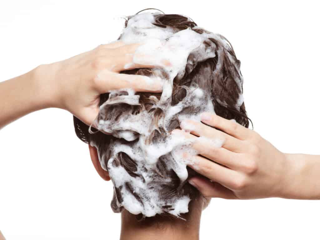 Woman washing her hair with shampoo