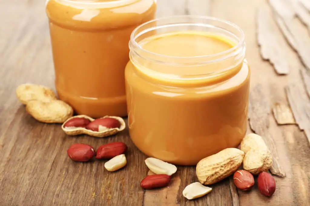 Jars of creamy peanut butter on wooden table