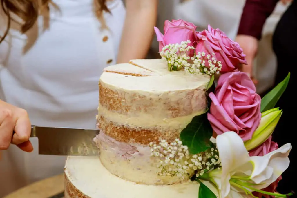 Photo of rustic vanilla wedding cake with pink roses