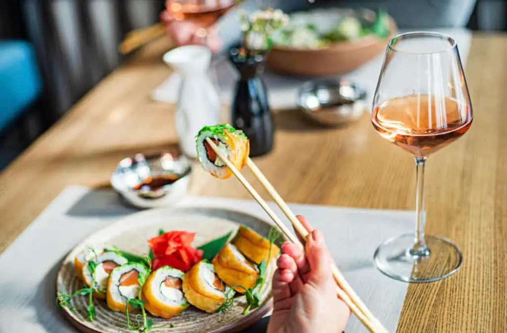 Sushi on plate and glass of wine