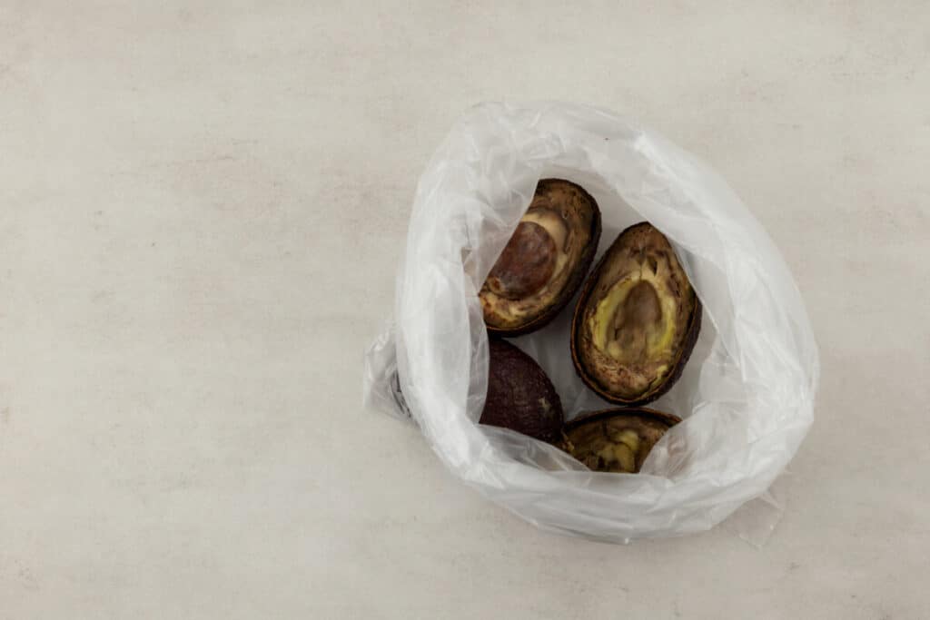 Brown avocados silced in half in a plastic bag