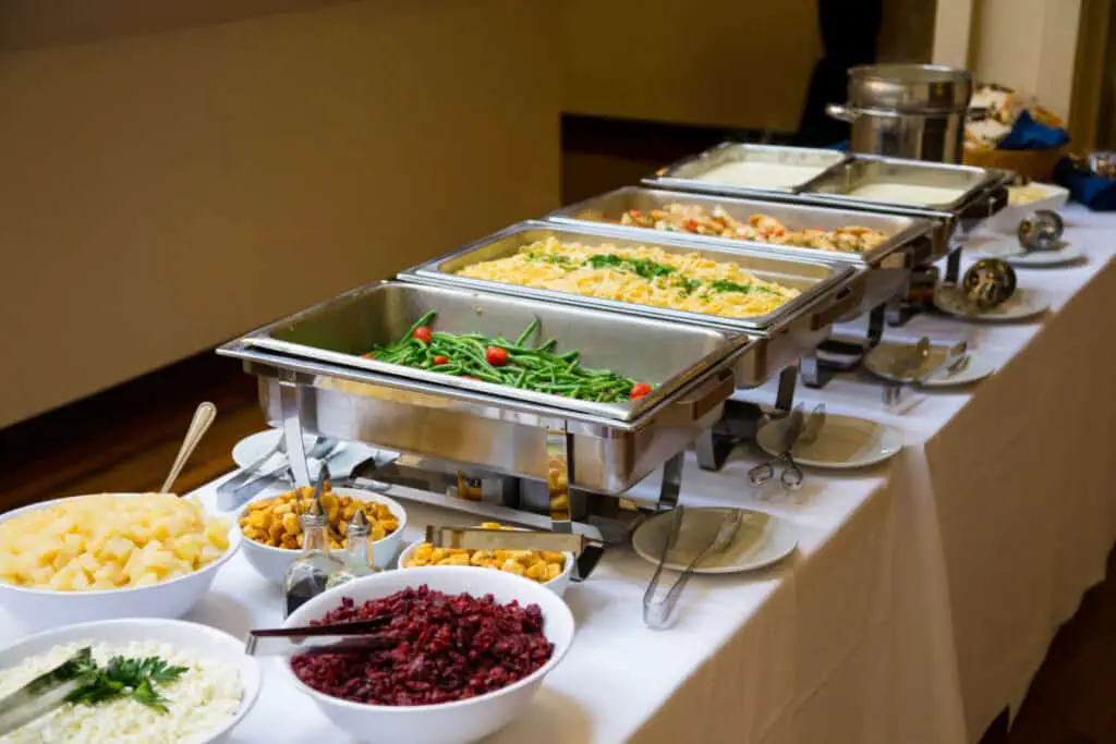 Buffet table with potatoes, green beens, and chicken
