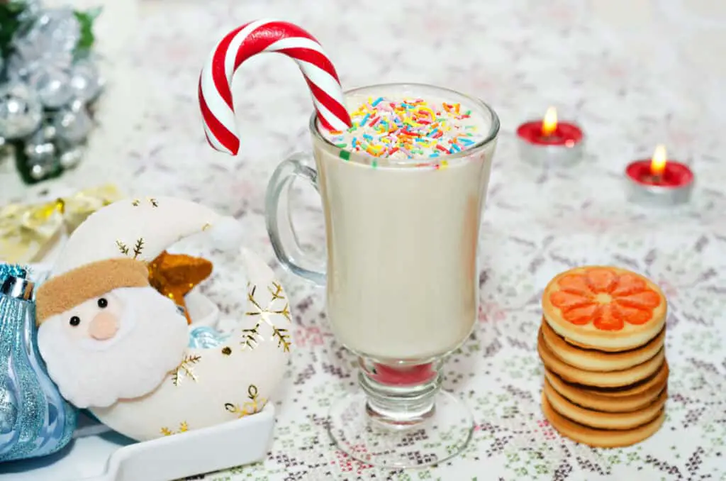 Christmas themed milkshake and cookies on a white tablecloth