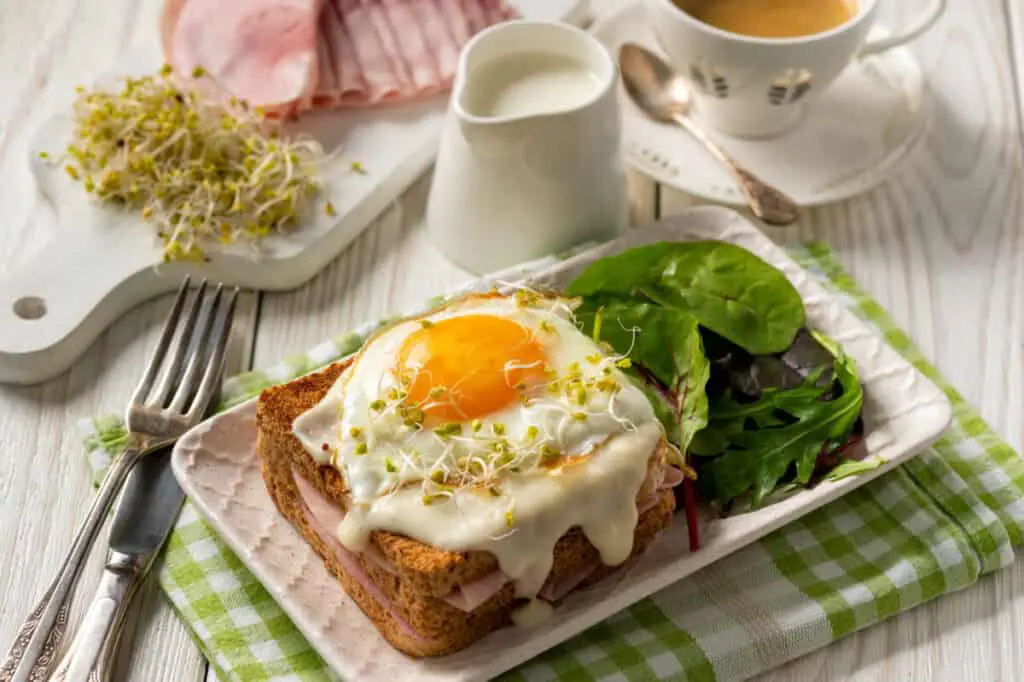 Hot french toasts with ham, cheese and egg and spinach salad