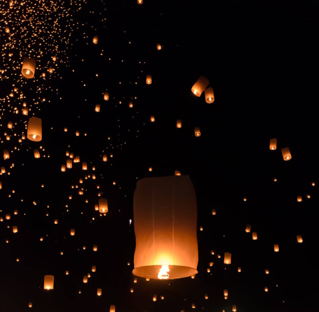 Hundreds of floating lanterns in a dark sky
