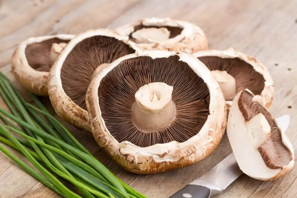 Sliced portobello mushrooms on a wooden table
