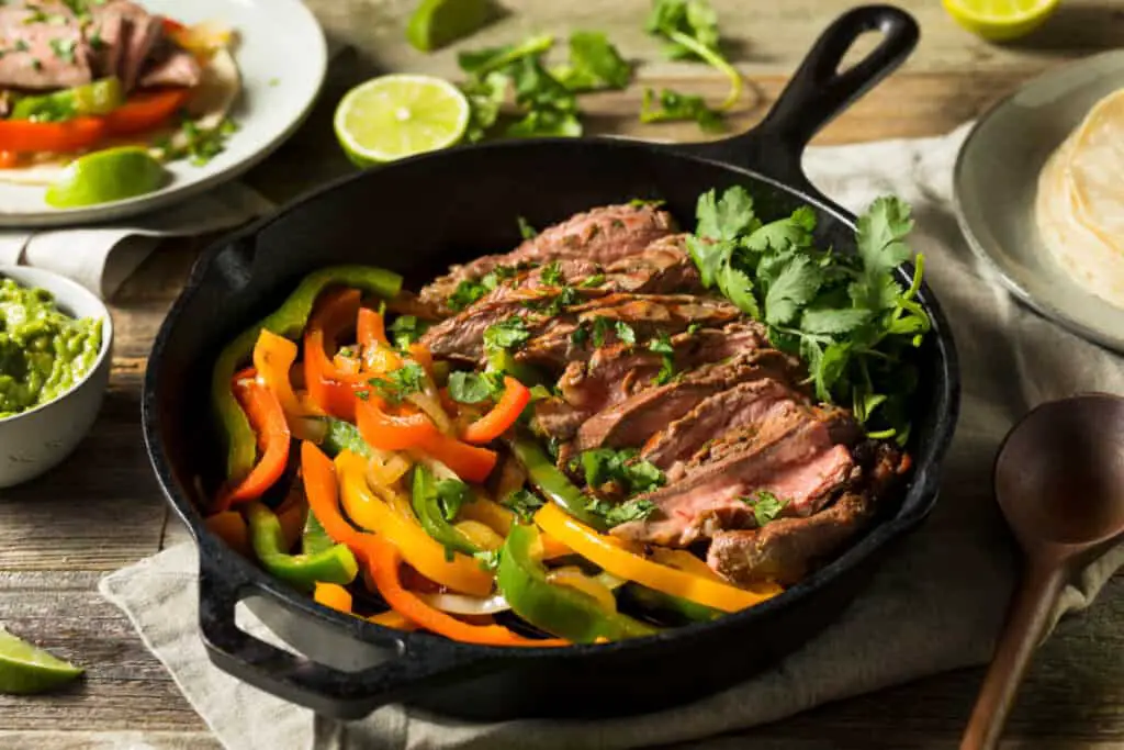 Steak fajita meat and bell peppers in a skillet