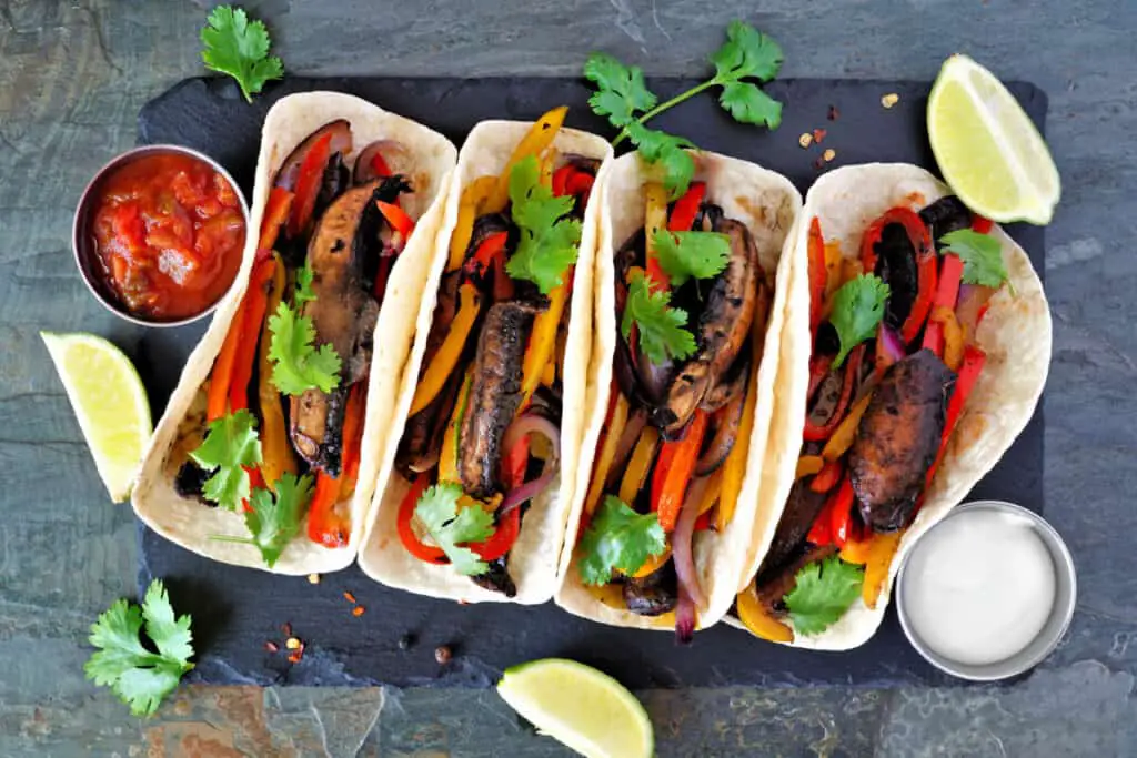 Steak fajitas with flour tortillas, salsa, and sour cream