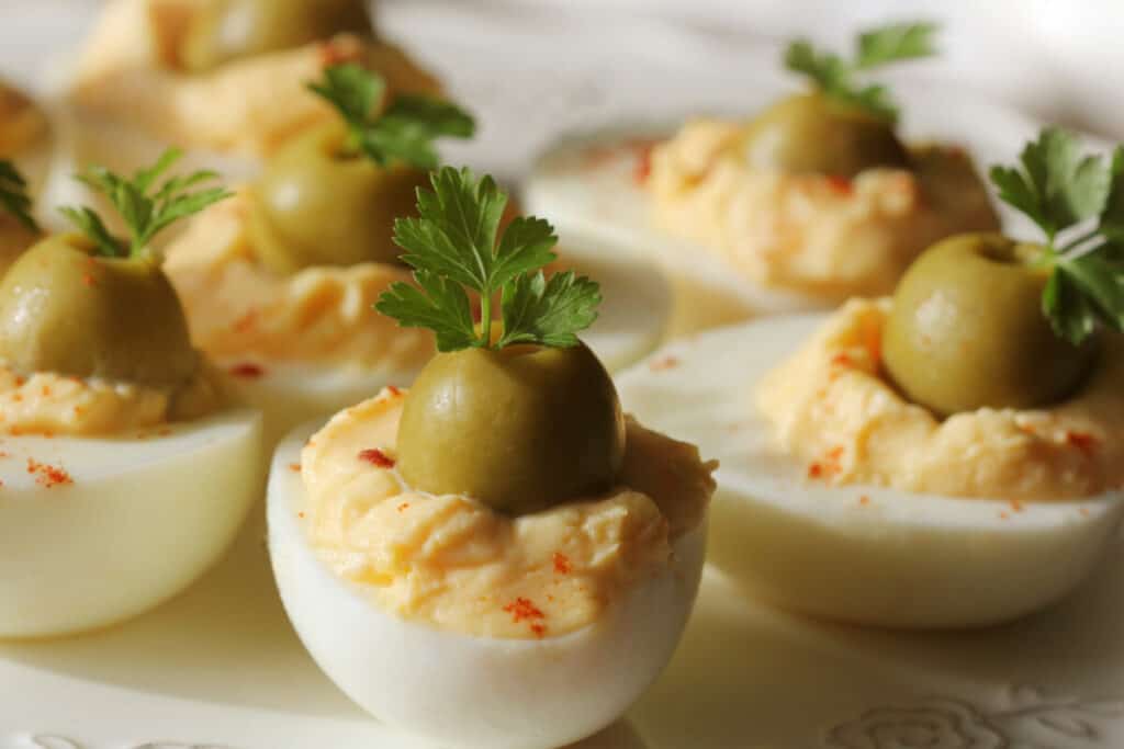 Deviled eggs with green olives, paprika, and parsley