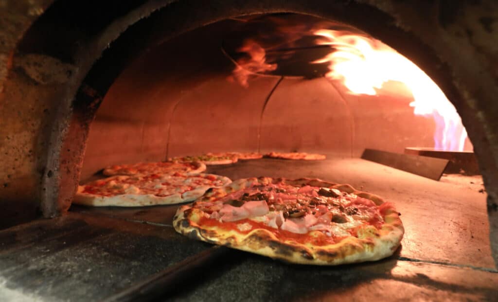 Pizza being removed from the Italian pizza oven with a special shovel