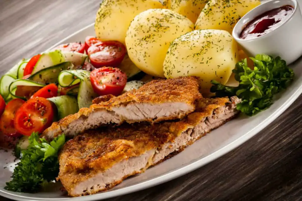 Fried pork chops, potatoes, and vegetable salad