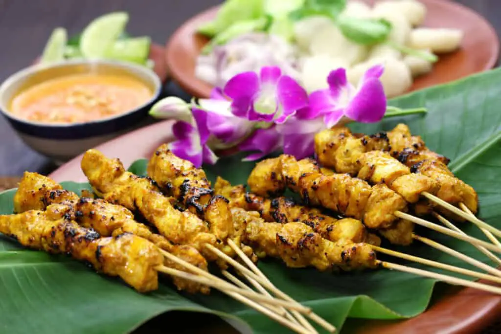 Chicken on skewers with purple flowers as decoration
