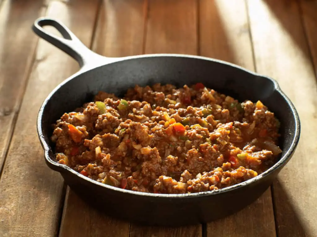 Cooked sloppy joe mix in iron skillet made with ground beef