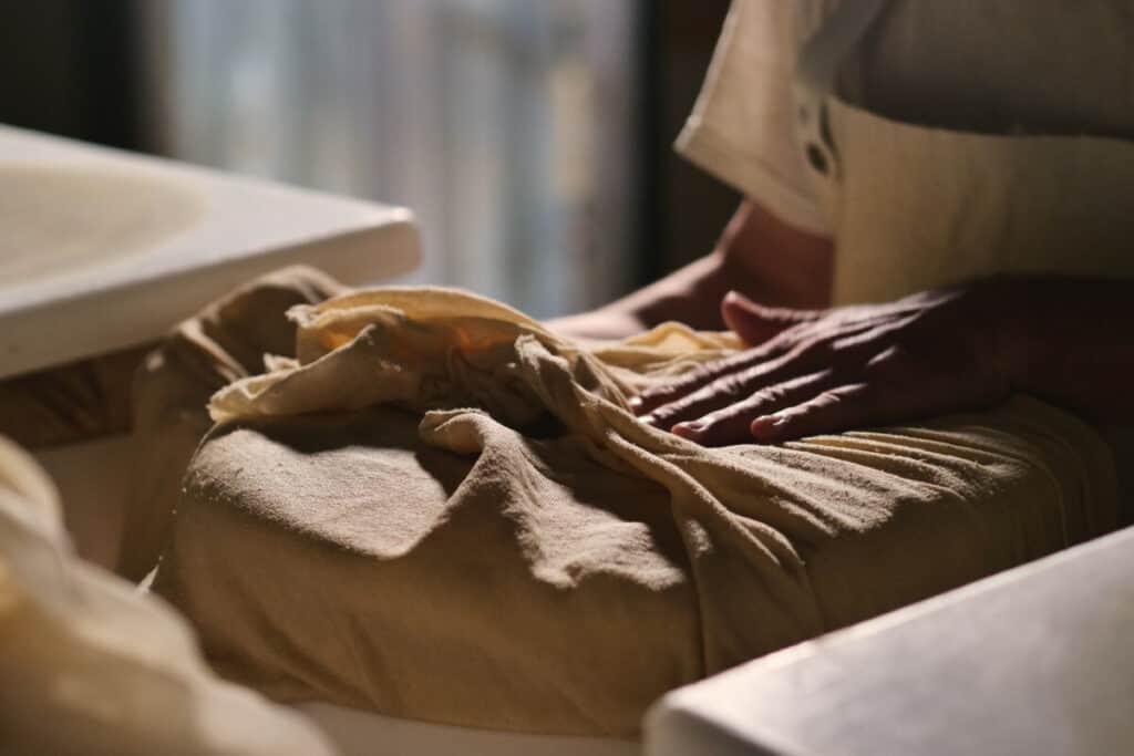 
A cheesemaker prepares a form of Parmesan cheese using fresh and organic milk. The processing is done following the ancient Italian tradition