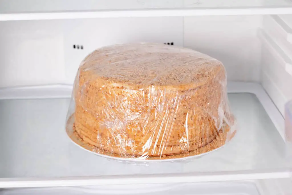 Honey cake packed in cling film in a refrigerator