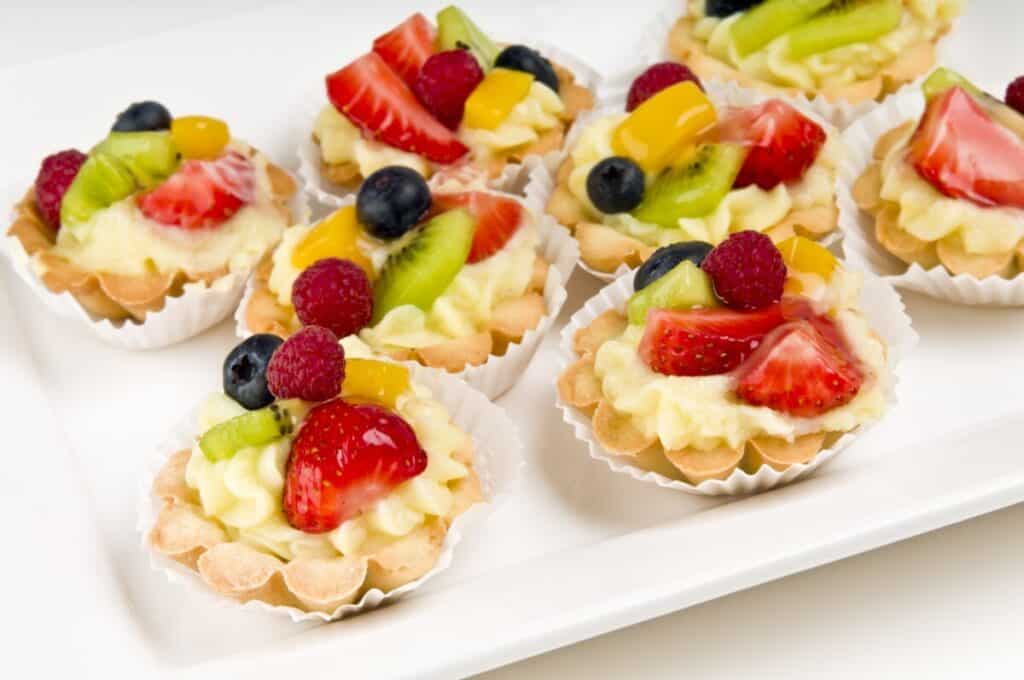 Kiwi, strawberry, peach, and blueberry fruit tart on a white plate