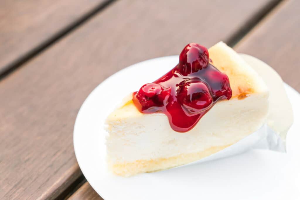 Piece of cherry cheesecake on a white plate
