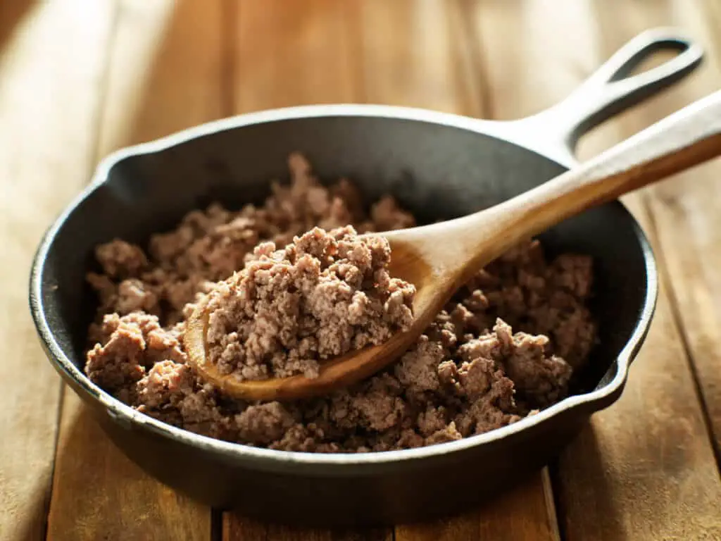 Spoonful of freshly cooked ground beef from iron skillet