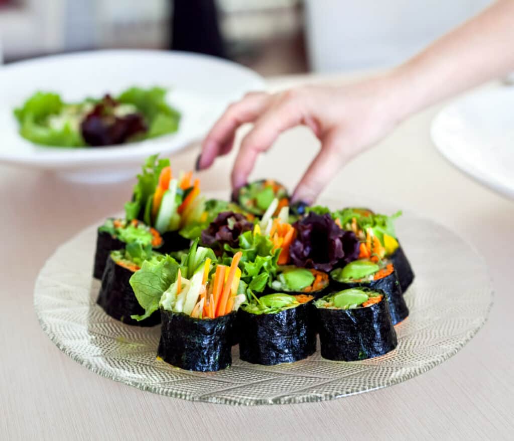 Raw vegan sushi rolls with carrots, avocados, and butter lettuce