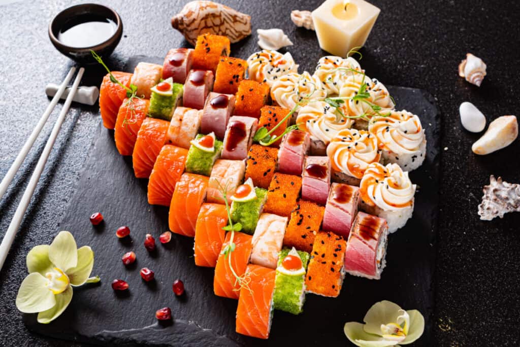 Assorted colorful sushi on a black platter