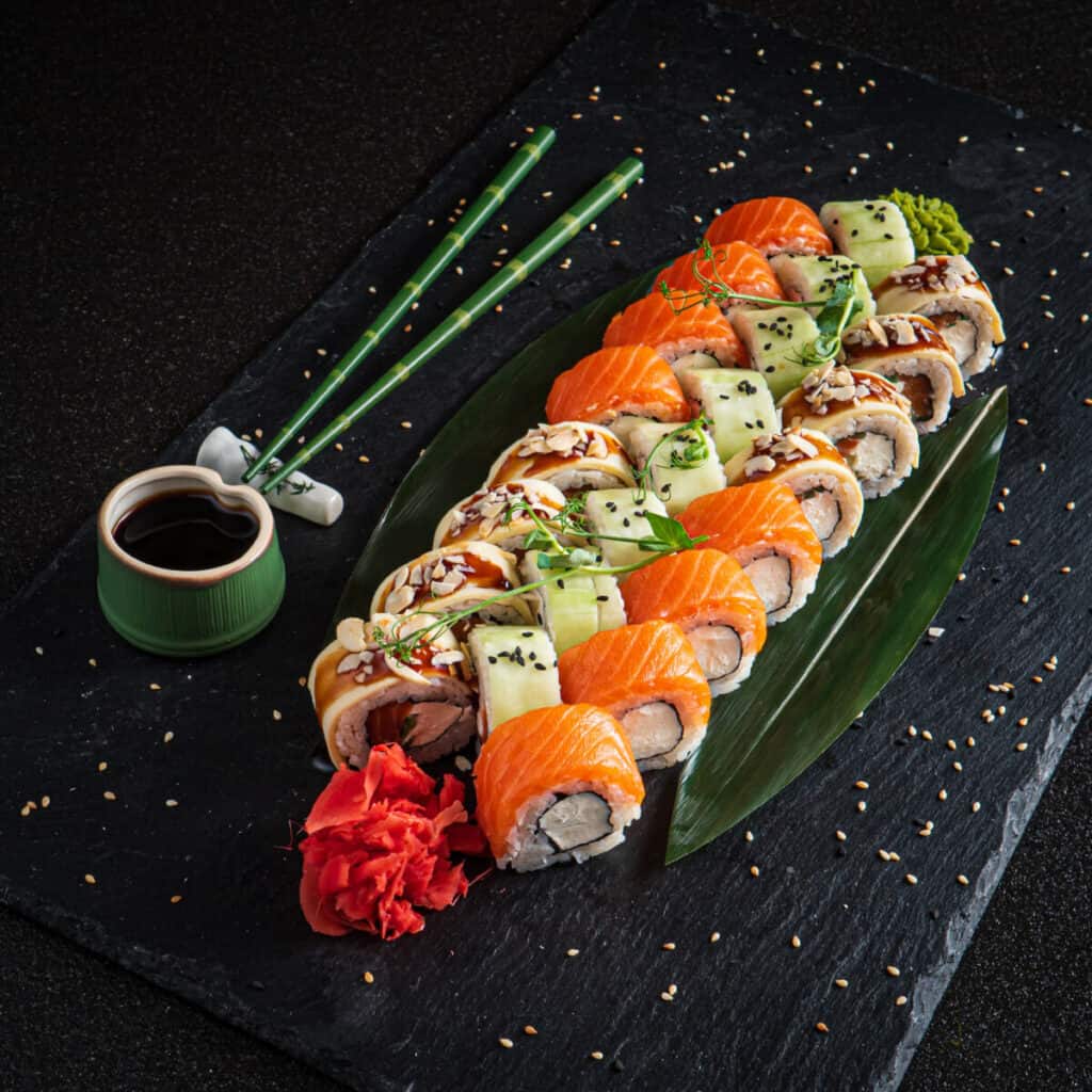 Assorted colorful sushi on a black serving tray