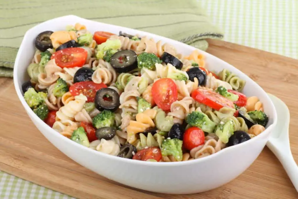 Bowl of pasta salad with tomatoes, black olives, and broccoli