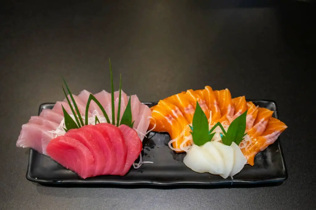 Fresh raw sashimi fish set  in a black dish on black table