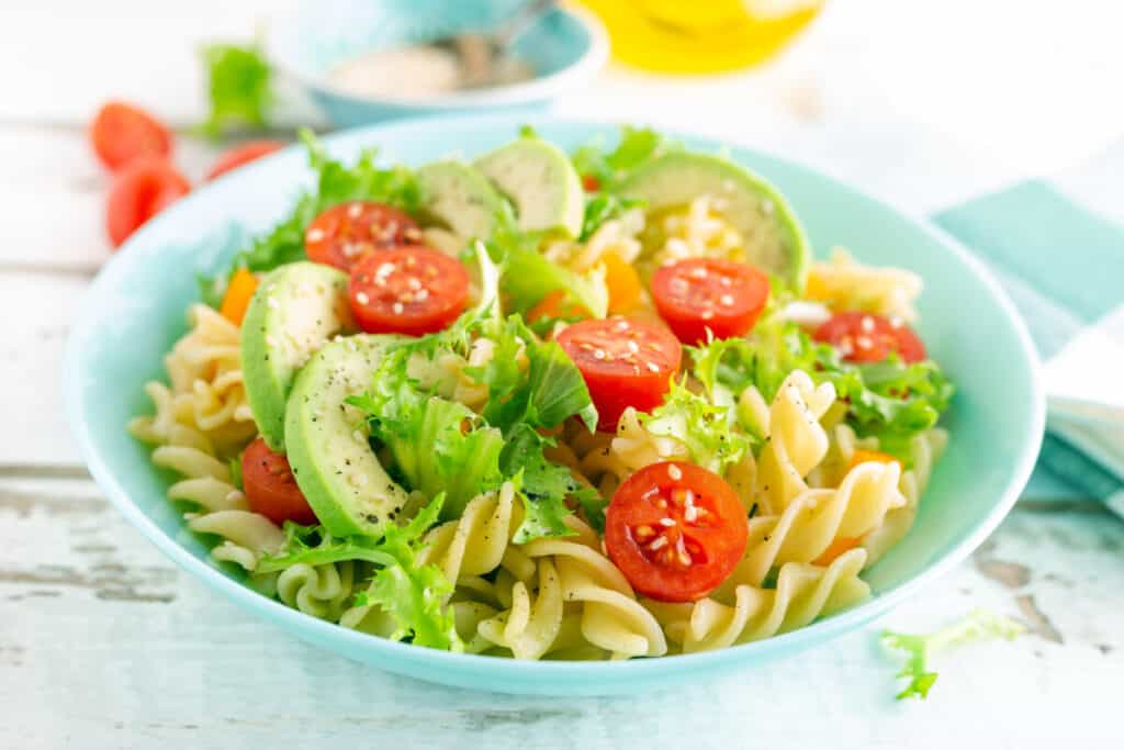 Pasta salad with avocado, fresh tomato, pepper and lettuce