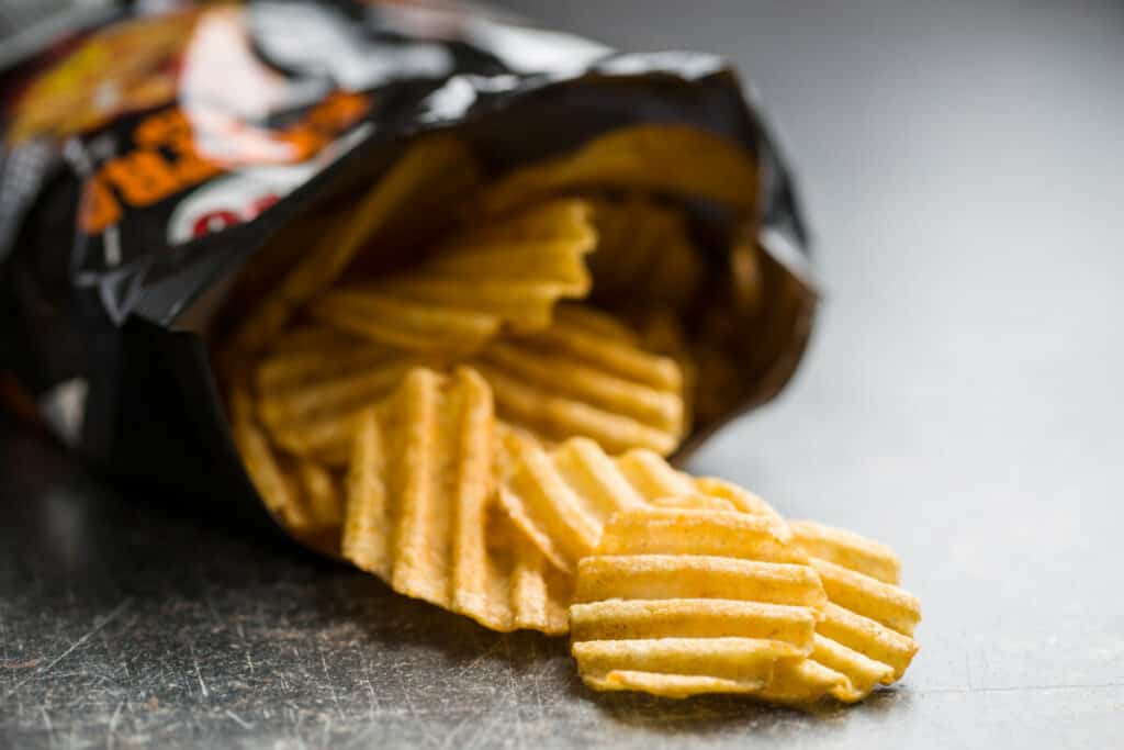 Crinkle cut potato chips poured out from bag.