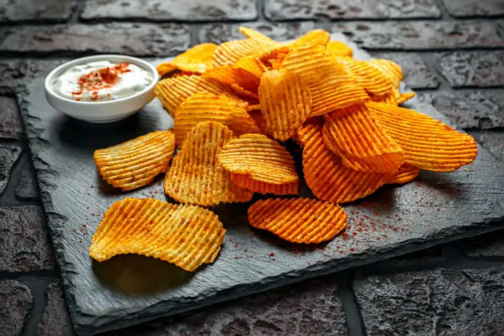 Potato chips with red paprika and white dipping sauce