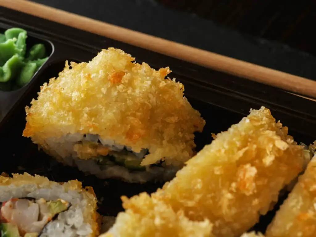 Pieces of tempura sushi and chopsticks.
