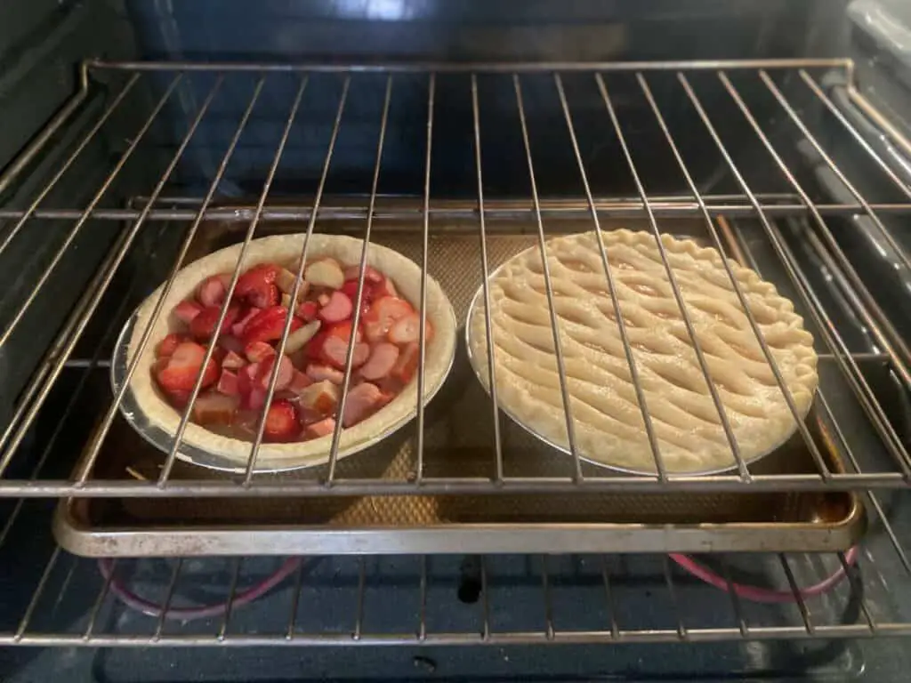 Apple and strawberry pies baking in an oven