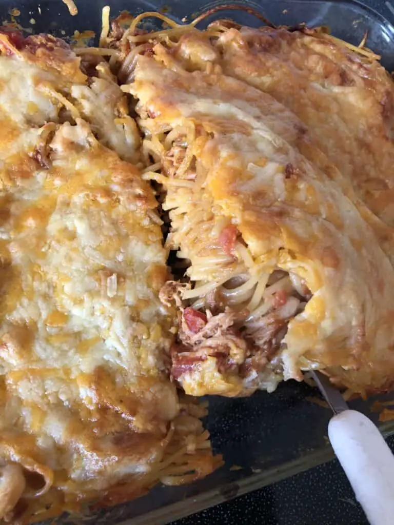 cooked chicken spaghetti bbq casserole being removed from the pan